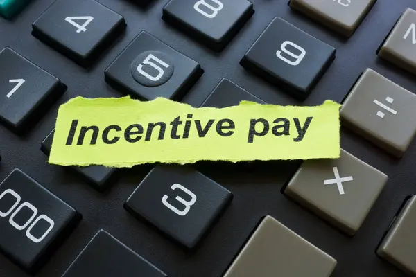 stock image Incentive pay word on the green piece of paper.