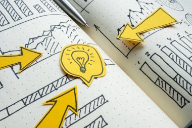 Oklar bir ampulü ve finansal grafikleri gösteriyor. İş stratejisi ve yenilikçi çözümler.