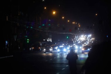 Kyiv, Ukrayna - 16 Aralık 2022 Ukrayna 'nın başkenti Kyiv' de elektrik kesintisi. Sokak lambası olmayan ana caddeler. Sadece geçen arabaların ışıkları görülebilir..