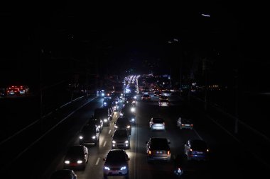 Kyiv, Ukrayna - 16 Aralık 2022 Ukrayna 'nın başkenti Kyiv' de elektrik kesintisi. Sokak lambası olmayan ana caddeler. Sadece geçen arabaların ışıkları görülebilir..