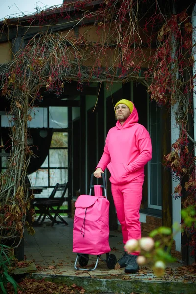 Ροζ Άνδρας Ποζάρουν Εξωτερικό Χώρο Ροζ Αθλητικό Κοστούμι Κυλιόμενη Τσάντα — Φωτογραφία Αρχείου