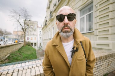 Kiev 'deki şehir sokağında şık kahverengi paltolu, sakallı çekici, modaya uygun bir adam.