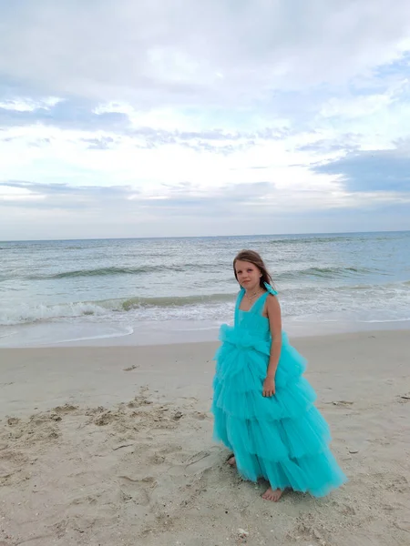 穿着晚礼服在海滩上散步的可爱的小女孩 — 图库照片