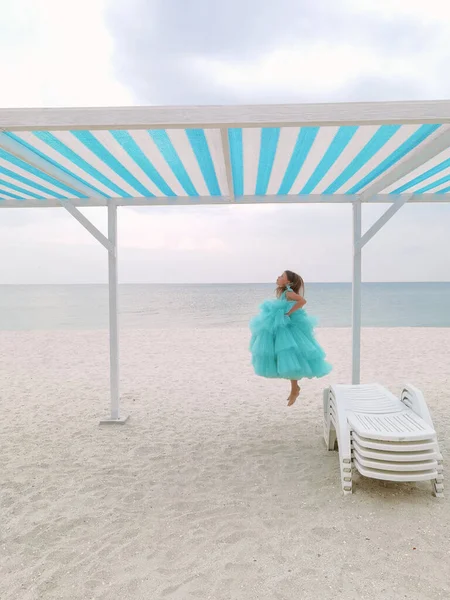 穿着薄荷裙的小女孩正在海滩上跳 — 图库照片