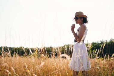 Açık çayırda altın gün batımı ışığında kadın portresi. Bahar ve yaz yaşam tarzı. Refah ve zen, açık havada meditasyon faaliyetleri gibidir. Hayatı sevmek