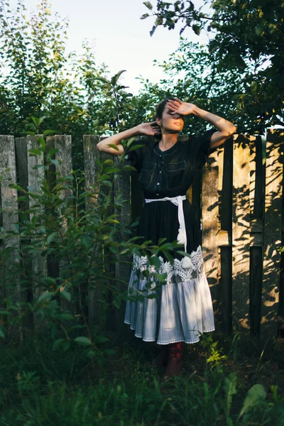 若いファッショナブルな女性は田舎の家の庭や裏庭のフェンスの近くに立っています 夏時間 ルーチン リラックス 収穫の概念 — ストック写真