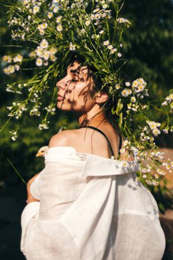 Güzel genç bir shuman kafasında papatya çelengiyle ve ellerinde civciv tutuyor..