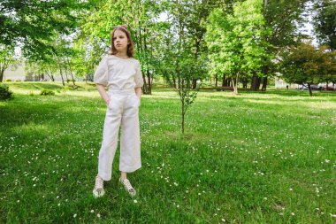 Güneşli ve güzel bir günde kız şehir parkında tek başına vakit geçiriyor. Yalnız zaman geçirmek ve doğada özgürlüğün tadını çıkarmak. Huzurlu atmosfer.