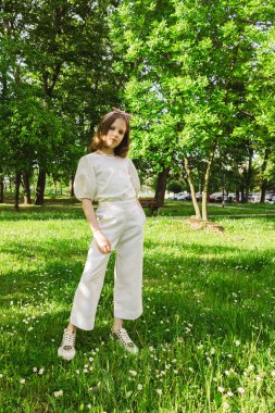 Güneşli ve güzel bir günde kız şehir parkında tek başına vakit geçiriyor. Yalnız zaman geçirmek ve doğada özgürlüğün tadını çıkarmak. Huzurlu atmosfer.