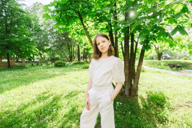 Güneşli ve güzel bir günde kız şehir parkında tek başına vakit geçiriyor. Yalnız zaman geçirmek ve doğada özgürlüğün tadını çıkarmak. Huzurlu atmosfer.