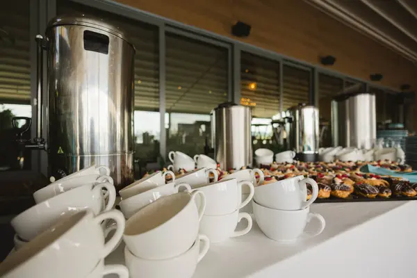 Coffee, cups on catering table at conference or wedding banquet. Group of empty white ceramic cups for coffee or tea in outside buffet at the business meeting event or hotel.