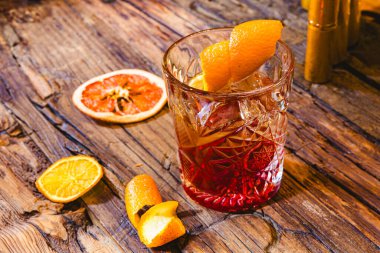 Buzlu, portakal dilimli, koyu ahşap arka planlı, eski moda bir kokteyl. Sığ dof.