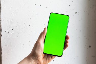 Boş yeşil ekranlı akıllı cep telefonu tutan kişinin görüntüsü
