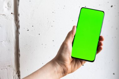 Boş yeşil ekranlı akıllı cep telefonu tutan kişinin görüntüsü