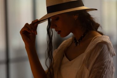 Beyaz elbiseli güzel bir kadın poz veriyor. Güzellik, moda. Saç bakımı. Kozmetik