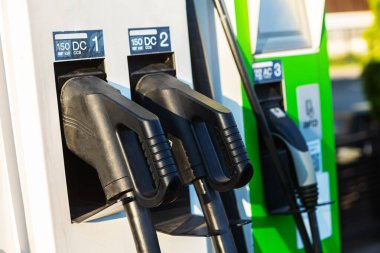 EV şarj ve elektrikli araba şarj istasyonu EV pili şarj istasyonu, elektrikli motoru olan araç prizi, EV şarjı temiz enerji, araba parkındaki şarj noktası.