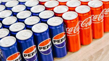 Kyiv, Ukraine - November 5, 2024: Close-up of neatly arranged Pepsi and Coca-Cola cans, showcasing a vibrant contrast of their iconic blue and red branding clipart