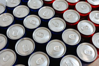 Overhead view of neatly arranged red and blue beverage cans with silver tops, symbolizing simplicity, refreshment, and modern design. Ideal for themes related to beverages, packaging, and minimalism. clipart