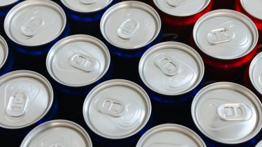 Temiz düzenlenmiş gümüş kapaklı kırmızı ve mavi içecek kutuları, basitliği, ferahlığı ve modern tasarımı sembolize ediyor. İçecekler, ambalaj ve minimalizm ile ilgili konular için ideal.