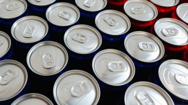 Temiz düzenlenmiş gümüş kapaklı kırmızı ve mavi içecek kutuları, basitliği, ferahlığı ve modern tasarımı sembolize ediyor. İçecekler, ambalaj ve minimalizm ile ilgili konular için ideal.