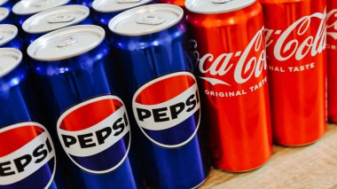 Kyiv, Ukraine - November 5, 2024: Close-up of neatly arranged Pepsi and Coca-Cola cans, showcasing a vibrant contrast of their iconic blue and red branding clipart