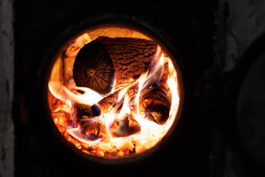 Close-up of burning wood logs inside a furnace with bright flames and glowing embers clipart