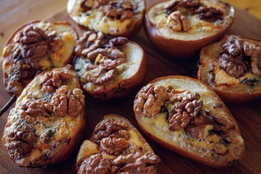 Baked pears topped with walnuts and blue cheese, capturing a rustic and comforting feel. clipart