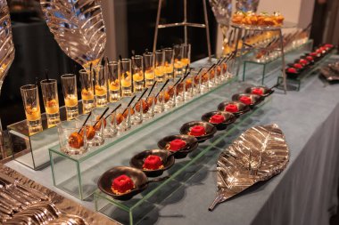 Krem peynirli ve rendelenmiş peynirli lezzetli küçük kırmızı kadife kekler bir rafta sergileniyor, büfede servis ediliyor.