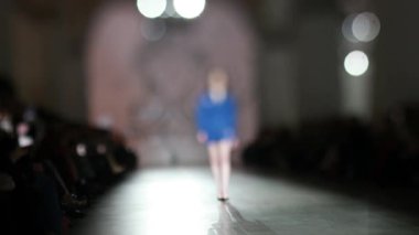 Moda pisti bulanık. Bulanık arkaplan. Tanımlanamayan modelin bulanık siluetleri binanın içinde hareket ediyor.