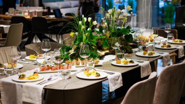 Lüks yemek için şık masa dekorları çiçek süslemeleri, gurme aperatifler, şık cam eşyalar ve sofra ortamları lüks etkinlikler için idealdir..