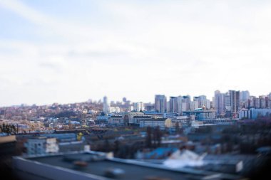 Kyiv, Ukrayna - 24 Nisan 2025: Parlak mavi gökyüzü altında modern ve eski mimarinin bir karışımını içeren çarpıcı bir eğik kayma şehir manzarası, büyüleyici bir minyatür model etkisi yaratıyor