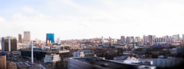 Kyiv, Ukrayna - 24 Nisan 2025: Parlak mavi gökyüzü altında modern ve eski mimarinin bir karışımını içeren çarpıcı bir eğik kayma şehir manzarası, büyüleyici bir minyatür model etkisi yaratıyor