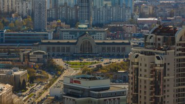 Kyiv, Ukrayna - 24 Nisan 2025: Gökyüzü manzarası tarihi Kyiv Merkez Tren İstasyonu etrafındaki dinamik kentsel çevreyi yakalıyor, işlek bir cadde, çeşitli mimari ve aydınlık gökyüzü altında çağdaş gökdelenler yer alıyor