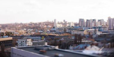 Kyiv, Ukrayna - 24 Nisan 2025: Parlak mavi gökyüzü altında modern ve eski mimarinin bir karışımını içeren çarpıcı bir eğik kayma şehir manzarası, büyüleyici bir minyatür model etkisi yaratıyor
