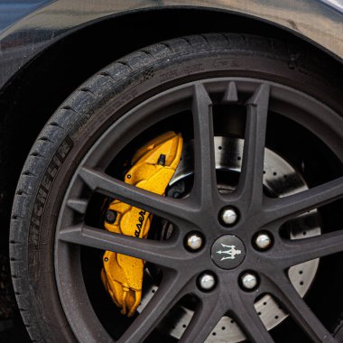 Kyiv, Ukrayna - 12 Haziran 2025: Maserati tekerleği, siyah jant telleri, öne çıkan sarı fren kalibreleri, ve tekerleğin üzerinde ikonik mızrak logosu ve Logo Michelin