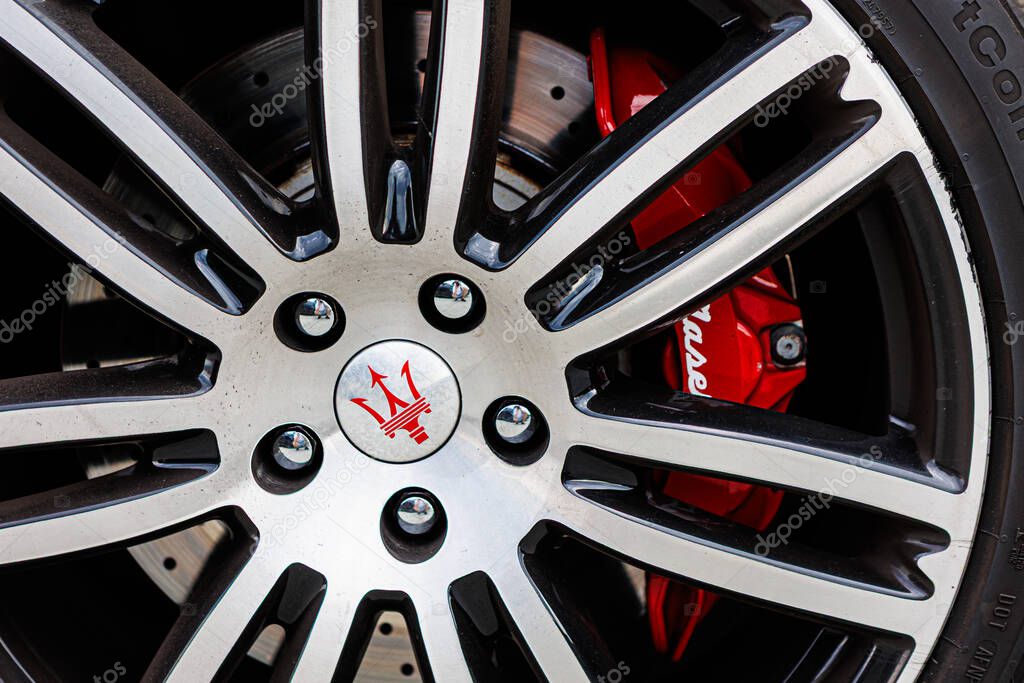 Kyiv, Ukraine - June 12, 2025: Close-up of a stylish Maserati wheel, highlighting the intricate spoke design, vibrant red brake caliper, and the iconic trident logo at the center, symbolizing automotive luxury and performance. Italclub gathering in K