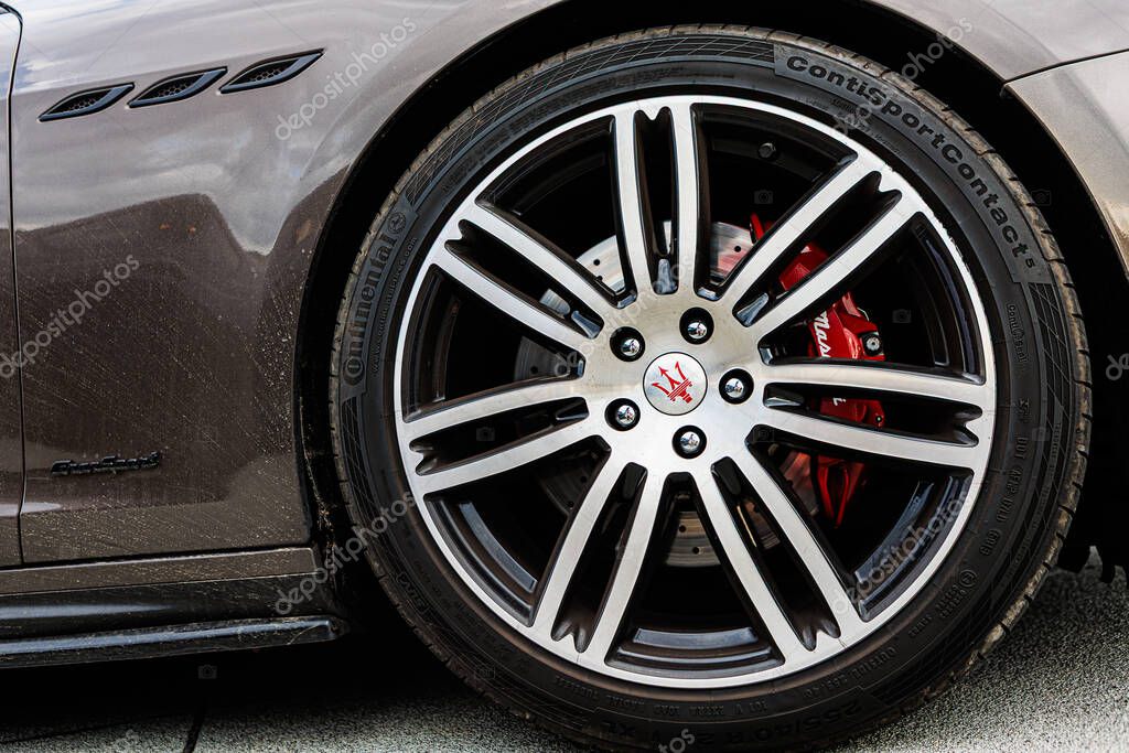 Kyiv, Ukraine - June 12, 2025: Maserati wheel, featuring matte black spokes, a prominent yellow brake caliper, and the iconic trident logo and Logo Continental on the tire. Italclub gathering in Kyiv.