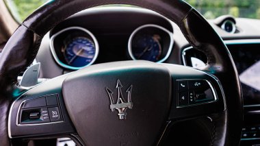 Kyiv, Ukrayna - 12 Haziran 2025: Sürücünün lüks bir Maserati içindeki perspektifi, zarif deri direksiyon simidi, ikonik mızrak logosu ve sofistike gösterge paneli. Bu görüntü kontrol, başarı, lüks yaşam tarzı kavramlarını çağrıştırıyor.