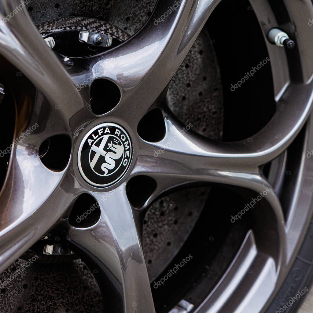 Kyiv, Ukraine - June 12, 2025: Close-up of a stylish grey alloy wheel featuring the iconic Alfa Romeo logo, embodying Italian luxury, precision engineering, and automotive passion. Ideal for concepts of heritage, performance, sophisticated design, an