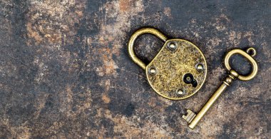 Old vintage key and padlock on a rusty grunge metal background. Escape room game banner.