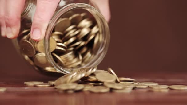 Tangan Menuangkan Koin Keluar Dari Gelas Jar Dalam Pemutaran Terbalik — Stok Video