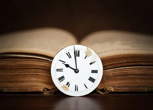 Old book and antique clock face. Storytelling, storyteller, time background.