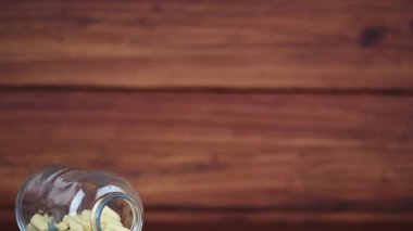 Masada beyaz kapsüller ve sarı haplar var. Beslenme takviyeleri, sağlıklı bir yaşam tarzı..