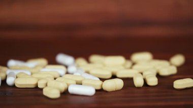 Masada beyaz kapsüller ve sarı haplar var. Uyuşturucu bağımlılığı, ilaç geçmişi.