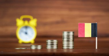 Belçika bayrağı ve çalar saati olan sikkeler. Ekonomi, mali veya emeklilik birikimleri ve planlama geçmişi.