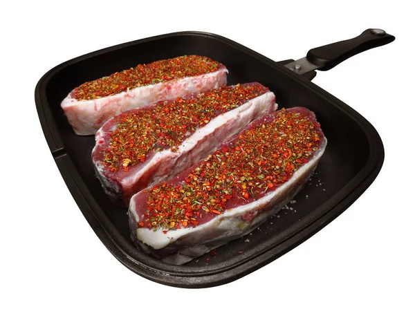 stock image Raw beef steaks with spices in a pan. Isolated on white. Clipping Path included.