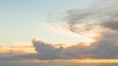 Ufukta yağmur ve fırtına bulutlarıyla okyanus üzerinde bulutlu gün batımı - zaman kavramı