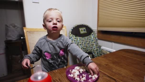 Młody Dzieciak Jedzenie Ręką Łyżką Drugiej Ręce Siedząc Samotnie Przy — Wideo stockowe