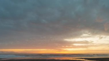 Sarı bir günbatımında okyanus sahilinin üzerindeki bulutlar - zaman kavramı