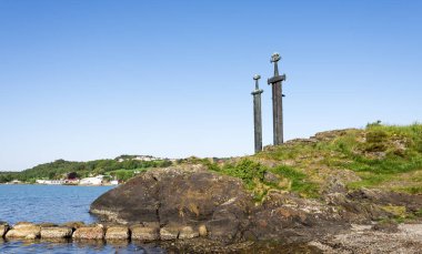 A view of Sword in Rock monument on the sea coast of Hafrsfjord fjord in a nice sunny summer day, Stavanger, Norway, May 2018